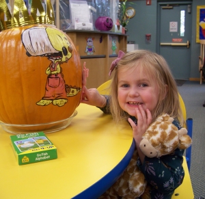 Weslee Pelton, 3, completed the 1,000 Books before Kindergarten program at the Reedsburg Public Library. She is posing with one of the six decorated pumpkins that are hiding throughout the library. Stop by to participate in the Pumpkin Hunt and ask for more information about 1,000 Books, a free early literacy program. (Submitted photo)