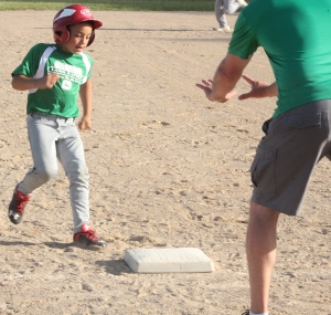 Cecil Alonso scoots safely into third base with instruction from his third-base coach for Slama’s Lawn and Sport in the championship game of the Minors for 9-10 year-olds in Reedsburg Little League Baseball last week. (Photo by Troy Matz)
